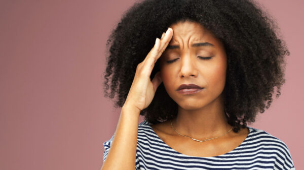 mulher negra com a mão na testa e cara decepcionada em fundo roxo