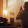 mulher ajoelhada em uma igreja fazendo oração com uma luz amarela entrando