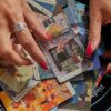 imagem de um par de mãos femininas acima de cartas de tarot que estão sob um pano preto com a mandala dos signos