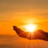 mão esticada ao ar livre na altura do pôr do sol alaranjado