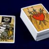 carta a morte do tarot ao lado de um deck de baralho de tarot em um fundo azul marinho